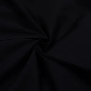Detailed macro shot showing the fine texture of black twill fabric for casual trousers