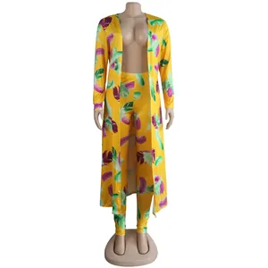 Close-up detail of sexy yellow two-piece set with vibrant feather print and long cardigan