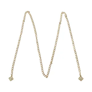 Detailed macro view of the delicate gold metal chain accessory featuring clover floral charms.
