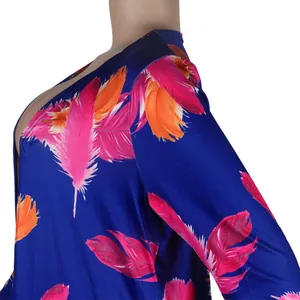 Close-up detail of vibrant pink and orange feather print on navy blue long sleeve cardigan fabric