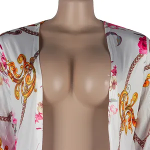 Close-up detail of sexy white cardigan featuring vintage floral and golden chain print