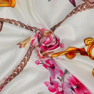 Close-up detail of soft satin fabric with vibrant floral and chain print patterns