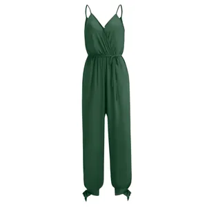Detailed view of a dark green spaghetti strap jumpsuit with a wrap V-neck and tie waist.