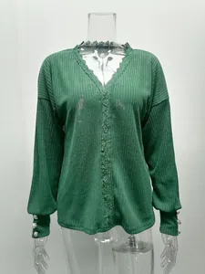 Detailopname van een groene trui met lange mouwen en een elegante kanten V-hals.