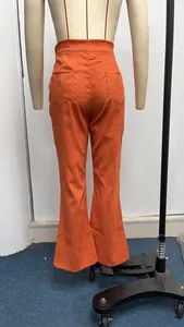 Detailed back view of high waisted orange corduroy flare pants displayed on a mannequin
