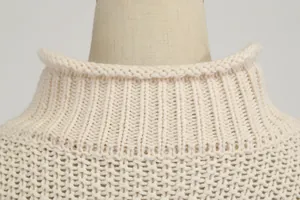 Detailed macro shot of beige chunky knit turtleneck sweater collar and texture