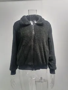 Détail d'une veste noire en polaire teddy avec fermeture éclair et poignets.