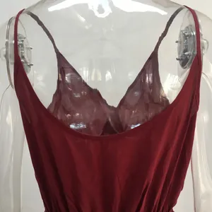 Macro detail of a burgundy backless camisole jumpsuit with thin spaghetti straps