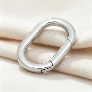 Détail d'un mousqueton ovale en acier inoxydable poli sur tissu doux