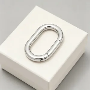 Gros plan d'un anneau mousqueton ovale en acier inoxydable argenté sur une boîte à bijoux.