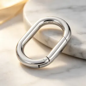 Zoom sur un fermoir mousqueton ovale poli en acier inoxydable montrant la texture.