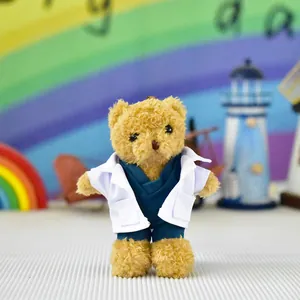 Detail of a cute teddy bear plush toy wearing white doctor coat and blue scrubs