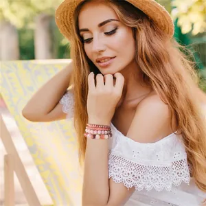 Detailed view of pink rose quartz and wood stone beaded bracelet set on model wrist