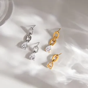 Detail view of gold and silver chain link earrings with brilliant pear-cut zircon stones