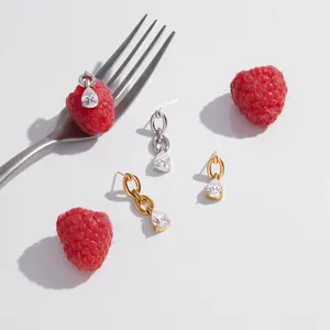Close-up of elegant pear-cut zircon stud earrings in gold and silver stainless steel