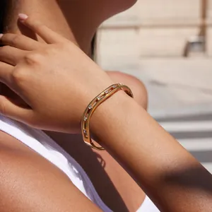 Detail of gold-plated stainless steel bracelet with cubic zirconia on woman's wrist