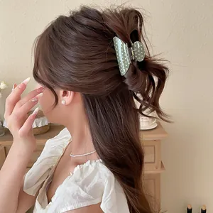Detail view of a green polka dot bow hair claw clip on a stylish updo hairstyle