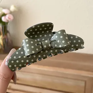 Detail view of the olive green polka dot bow hair claw clip with high gloss finish.