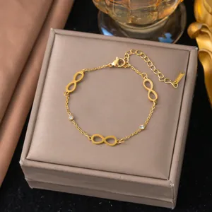 Vista dettagliata di un bracciale infinity placcato oro su una scatola regalo di lusso