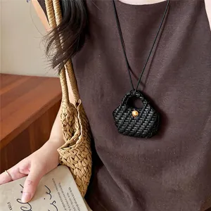 Detail of a vintage black woven leather handbag pendant necklace for a stylish look.
