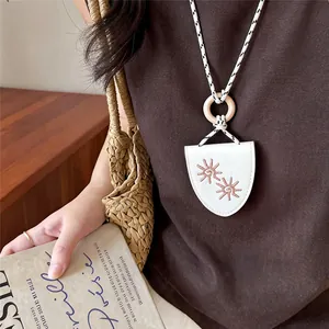 Detailed view of retro leather pendant eyeglass holder necklace with sun embroidery