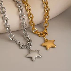 Close-up of gold and silver star pendants on chunky stainless steel link necklaces.