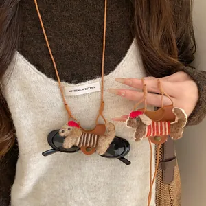 Detailed view of handmade flocked puppy eyeglass holder necklace with red hat and leather clip