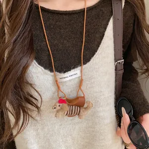 Detail shot of cute flocked puppy eyewear holder necklace on warm brown sweater