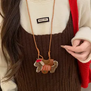 Close-up of a cute flocked dog necklace charm worn as a stylish sweater chain.