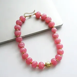 Elegante collana di perle acriliche marmorizzate rosa con accenti dorati e catena regolabile