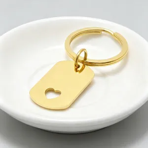Porte-clés poli en acier inoxydable doré avec étiquette cœur dans un petit plat blanc
