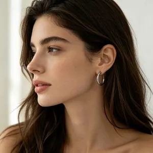 Lifestyle view of a model wearing a minimalist silver stainless steel hoop earring.
