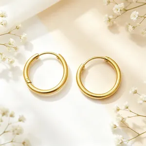 Macro view of minimalist gold stainless steel hoop earrings on a soft floral backdrop