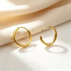 Close-up of minimalist golden stainless steel hoop earrings with smooth finish