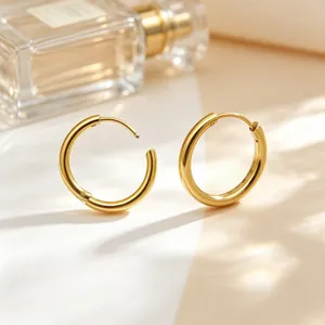 Detail of minimalist gold stainless steel hoop earrings with a smooth polished finish