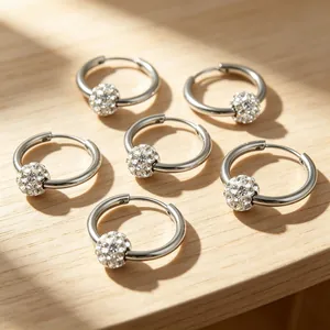 Detailed view of silver stainless steel hoop earrings with sparkling pavé crystal balls