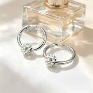 Detailed macro view of silver hoop earrings featuring a sparkling crystal-paved bead.