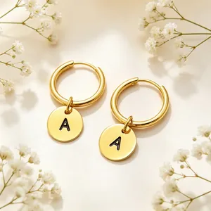 Detailed view of gold stainless steel hoop earrings with engraved letter A charms.