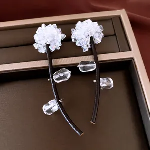Detailed view of crystal tassel earrings with black leather cords and silver needles