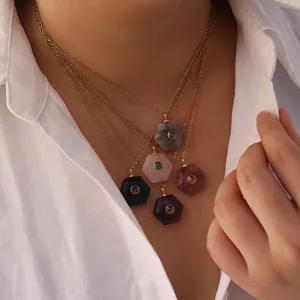 Close-up of five different hexagonal natural stone pendant necklaces on gold chains
