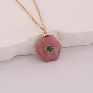 Close-up of hexagonal pink stone pendant with green gem on gold stainless chain