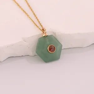 Close-up of hexagonal green natural stone pendant with garnet center on gold chain