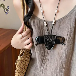 Close-up detail of black leather glasses holder lanyard with a cute polka dot heart charm