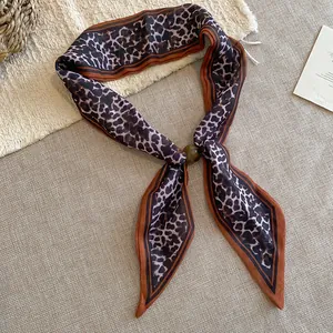 Vista detallada de un pañuelo de algodón con estampado de leopardo vintage y hebilla ámbar.