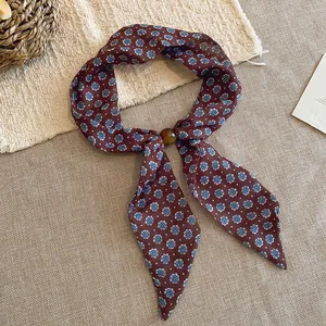 Pañuelo vintage de algodón y lino con estampado floral y hebilla decorativa.