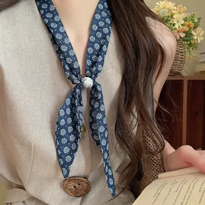 Primer plano de un pañuelo vintage de algodón y lino con estampado floral y anillo de mármol blanco