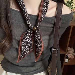 Foto detallada de un pañuelo vintage de algodón y lino con estampado de leopardo y perla.
