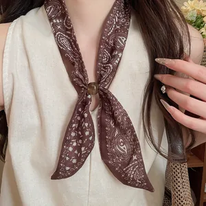 Primer plano de un pañuelo vintage de algodón y lino marrón con estampado paisley