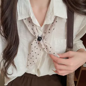 Primer plano de un pañuelo vintage de algodón y lino con lunares sobre una camisa blanca