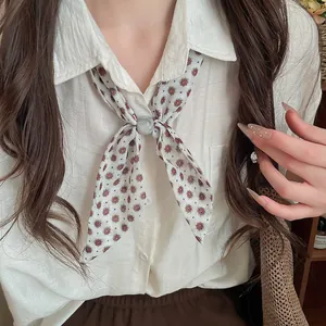 Detalle de pañuelo retro de algodón y lino con estampado floral y hebilla de anillo